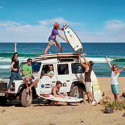 surfer with Landrover Defender at the beach