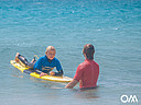 Surf instructor helps in the water to choose the waves
