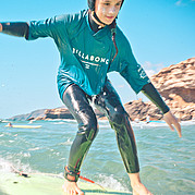 Surf girl gliding on a small green wave