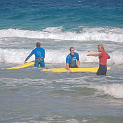 surf instructor explains the right position on the board