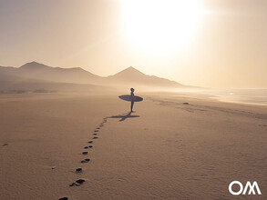 lone surfer on a beach in the south of Fuerteventura